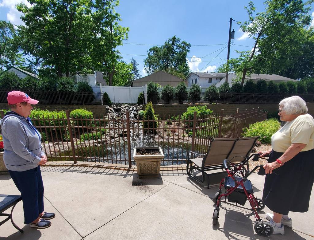 An image of two residents enjoying time outside at The Legacy of St. Anthony, St. Anthony.